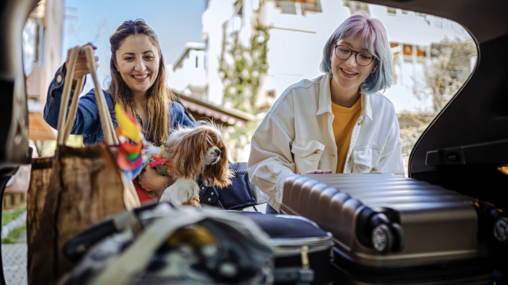 Two people are packing up a car with travel essentials